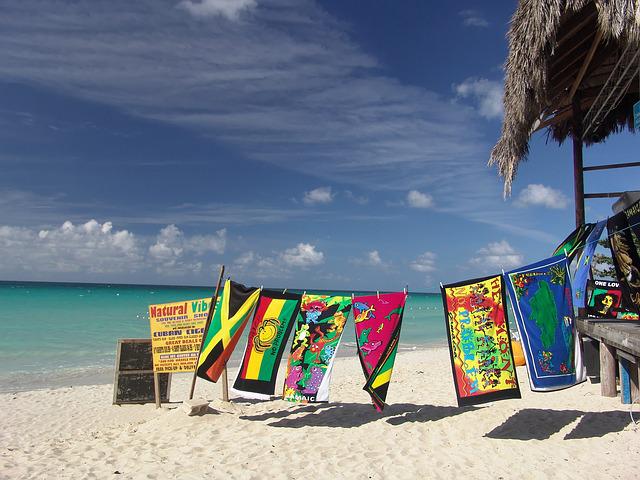 A beach in Jamaica with many towels and a bar