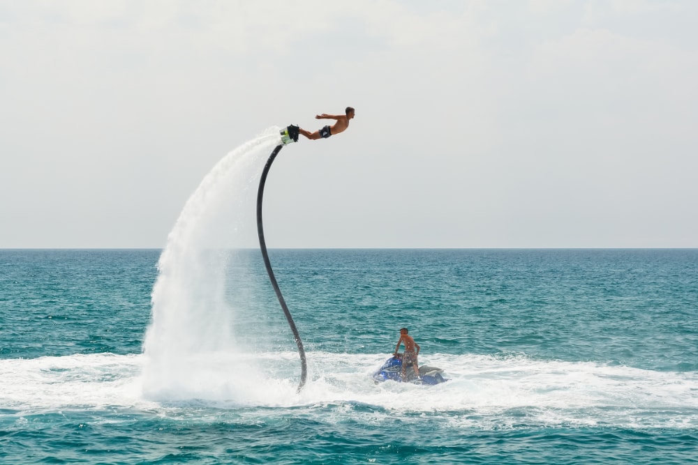 A man flyboarding high up in the air