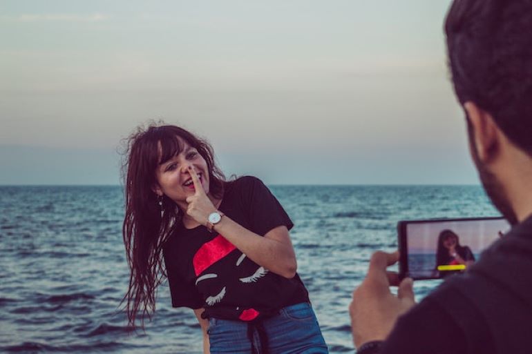 A man is taking a picture of a woman.
