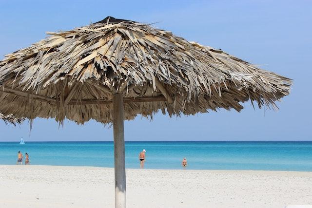 Umbrella on the beach with people in the background 