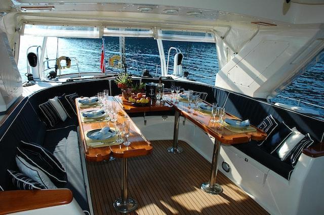 A meal served on a table with glasses and plates on a luxury yacht.