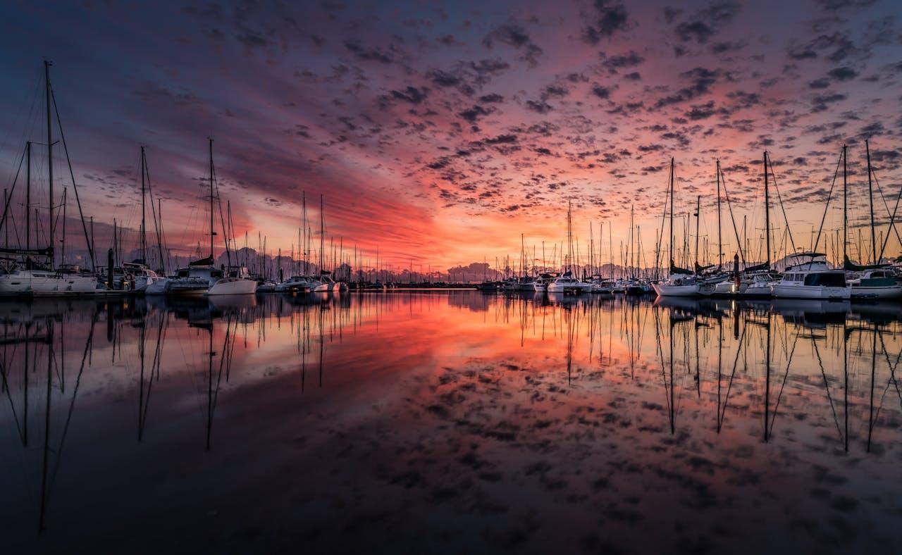    Assorted boats on bodies of water during sunset. 