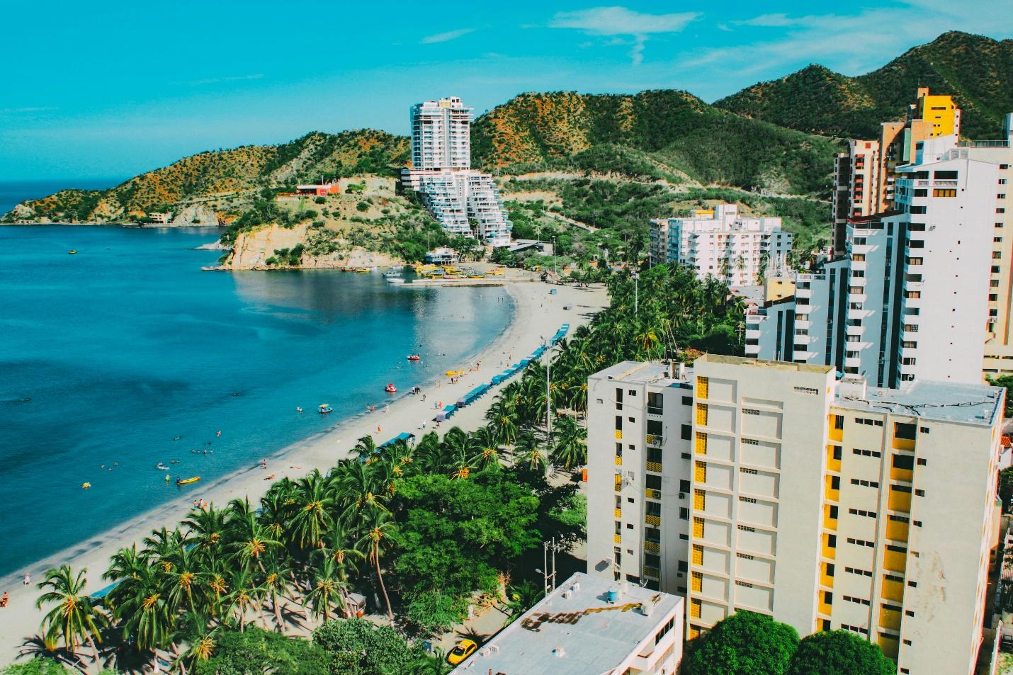 Tall, modern buildings near a beach with palm trees 